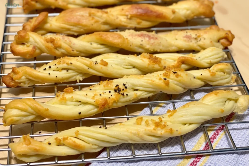 A plate of crispy cheese sticks with a side of red dipping sauce, ready to be enjoyed.